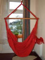 Hængekøjestol i rødt bomuldsstof giver komfort.