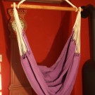 Hængende stol med en lilla baggrund for behagelige pauser.