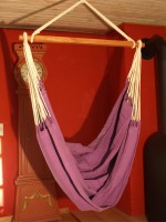 Hængende stol med en lilla baggrund for behagelige pauser.